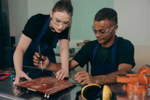 Girl and the guy are fixing eletronic parts